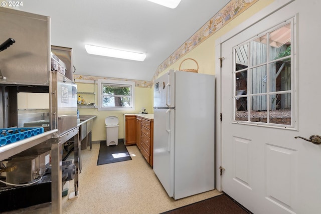 kitchen with white refrigerator and vaulted ceiling