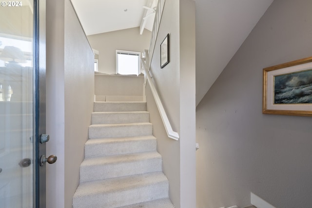 staircase featuring lofted ceiling with beams