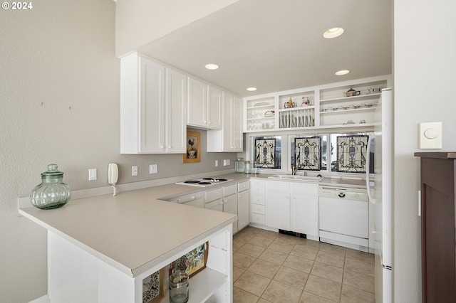 kitchen featuring light tile patterned flooring, white appliances, sink, kitchen peninsula, and white cabinets