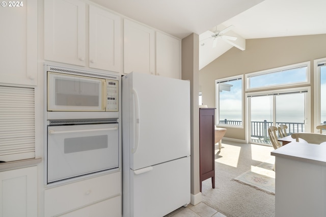 kitchen featuring lofted ceiling, ceiling fan, white appliances, white cabinetry, and light colored carpet