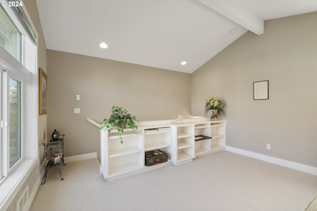 unfurnished room featuring vaulted ceiling with beams, carpet flooring, and a wealth of natural light