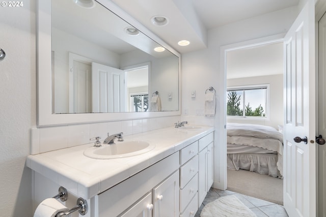 bathroom featuring tile patterned floors, vanity, and backsplash