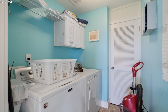 washroom with washer and clothes dryer and cabinets