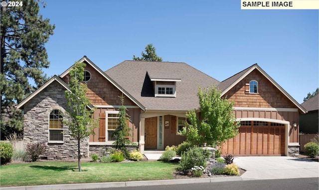 craftsman-style house featuring a garage and a front lawn