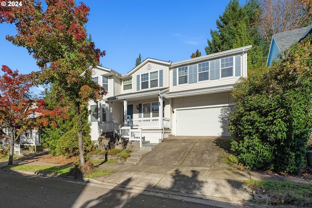 view of property with a garage and a porch