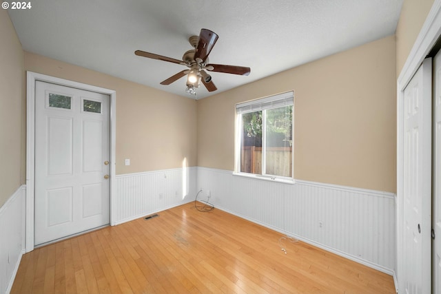 10909 SW Adele Dr, Portland, OR 97225 - unfurnished bedroom with a wainscoted wall, hardwood / wood-style flooring, a closet, and ceiling fan
