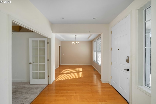 10909 SW Adele Dr, Portland, OR 97225 - entryway with a chandelier, light wood finished floors, a raised ceiling, and baseboards
