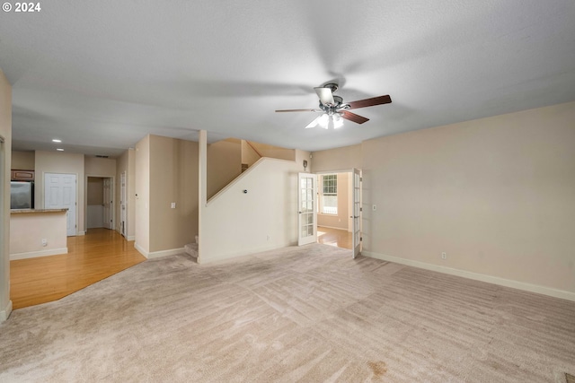 10909 SW Adele Dr, Portland, OR 97225 - unfurnished living room with light colored carpet, a ceiling fan, stairs, baseboards, and recessed lighting