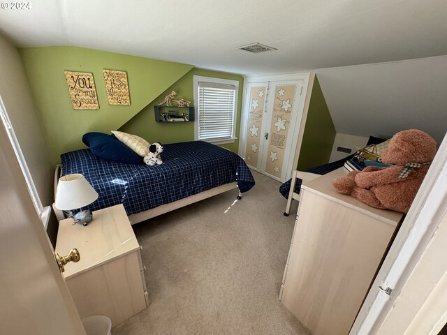 carpeted bedroom with vaulted ceiling