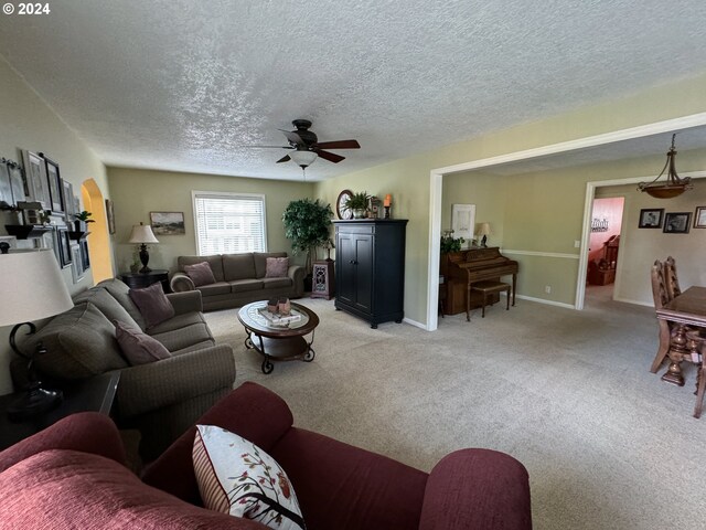 carpeted living room featuring a textured ceiling and ceiling fan