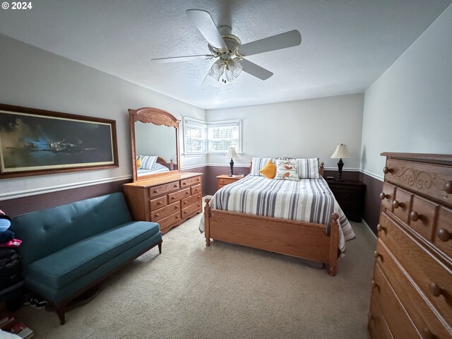 carpeted bedroom featuring ceiling fan and a textured ceiling