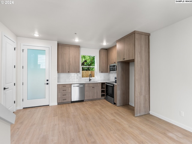 kitchen featuring light hardwood / wood-style flooring, sink, stainless steel appliances, and tasteful backsplash