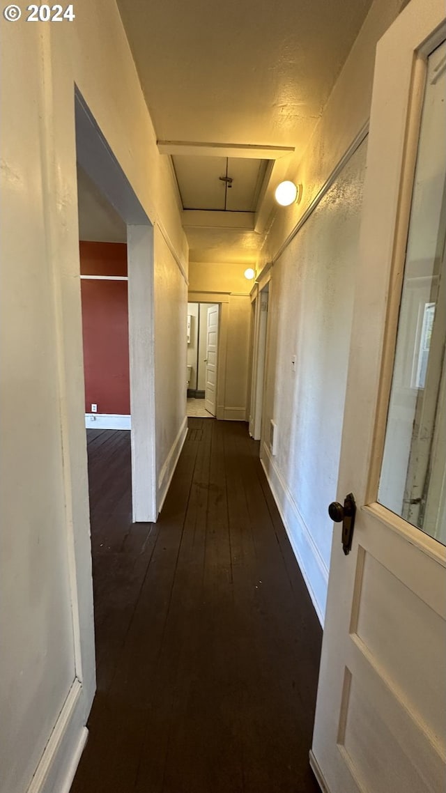 hallway with dark hardwood / wood-style flooring