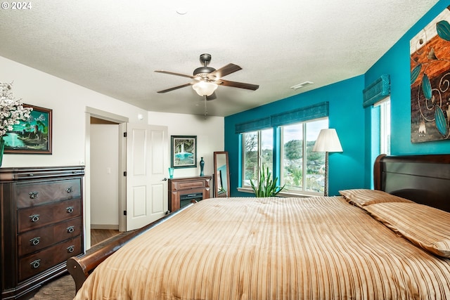 bedroom featuring hardwood / wood-style floors, a textured ceiling, and ceiling fan