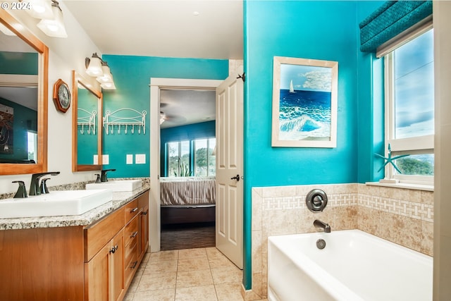 bathroom featuring tile patterned flooring, vanity, and a tub