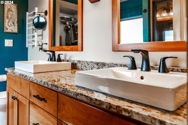 bathroom with vanity, toilet, and radiator