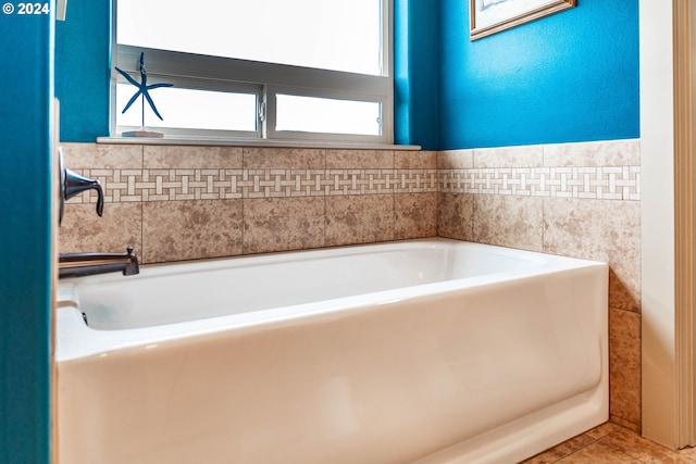 bathroom with tile patterned flooring and a tub