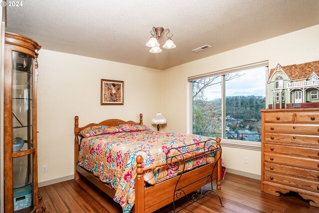 bedroom with wood-type flooring and a textured ceiling