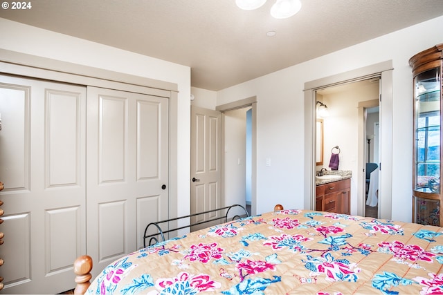 bedroom featuring ensuite bath, a closet, and sink