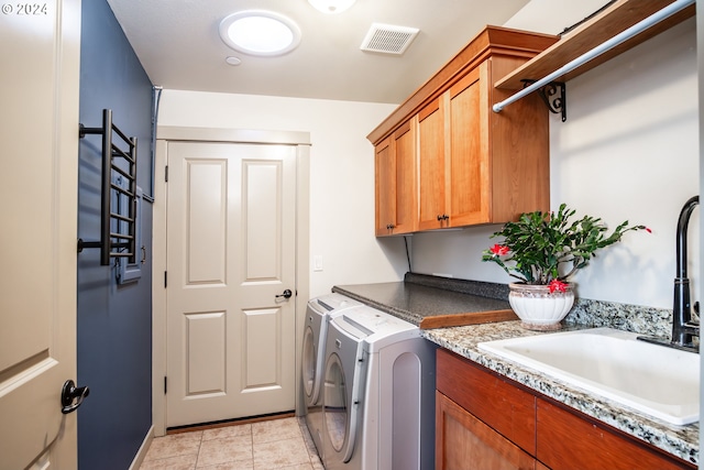 laundry area featuring cabinets, sink, light tile patterned floors, and washer and dryer