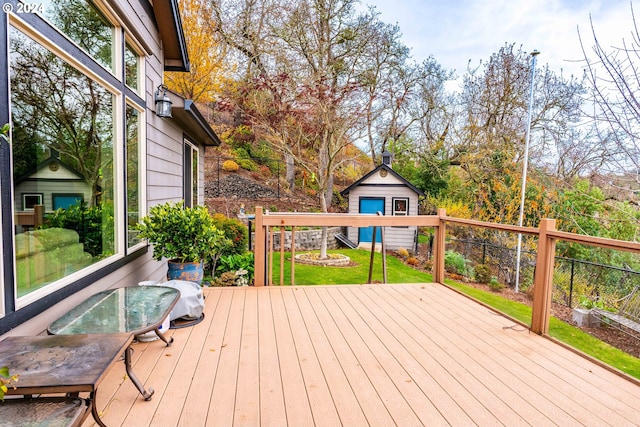 wooden deck featuring a yard and a storage unit