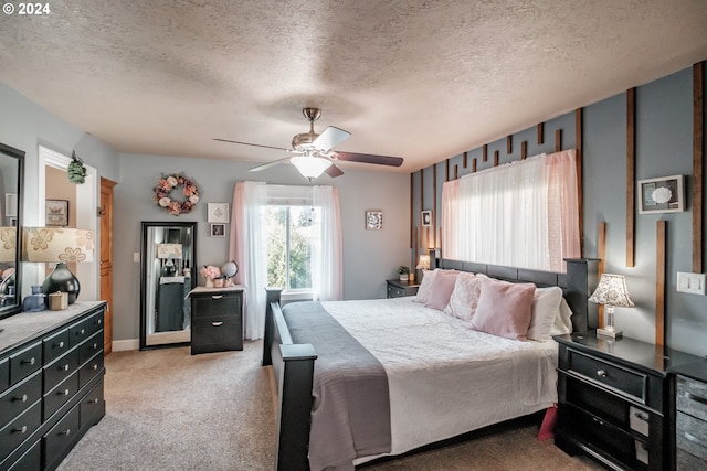 bedroom with a textured ceiling, light carpet, and ceiling fan