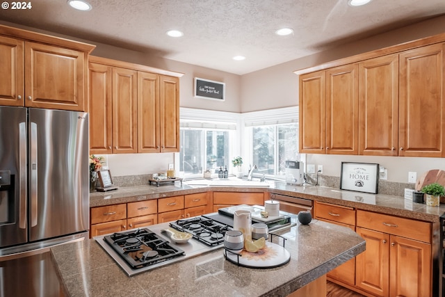 kitchen with stainless steel refrigerator with ice dispenser and a textured ceiling