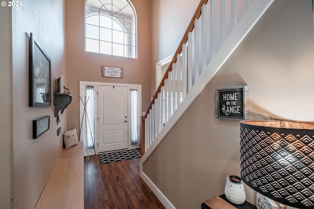 entryway with a towering ceiling and dark hardwood / wood-style floors