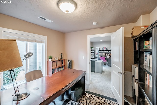 carpeted home office with a textured ceiling