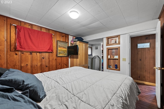 bedroom featuring wood walls and dark hardwood / wood-style floors