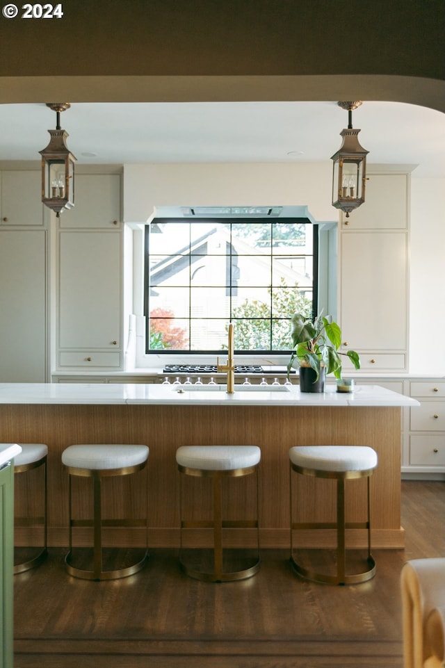 kitchen with a breakfast bar area, white cabinetry, and pendant lighting