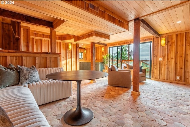 interior space featuring beam ceiling, wooden ceiling, and wooden walls