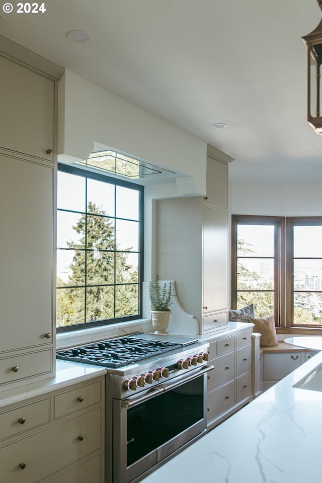 kitchen featuring high end range and light stone countertops