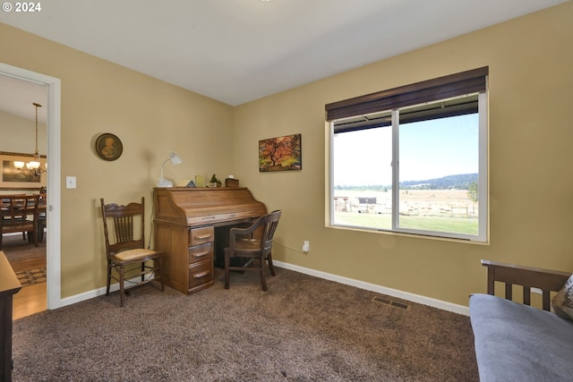 carpeted office with an inviting chandelier