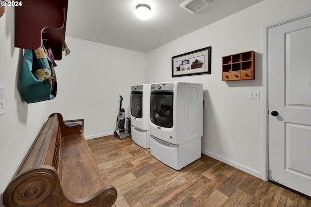 laundry area featuring wood-type flooring and separate washer and dryer