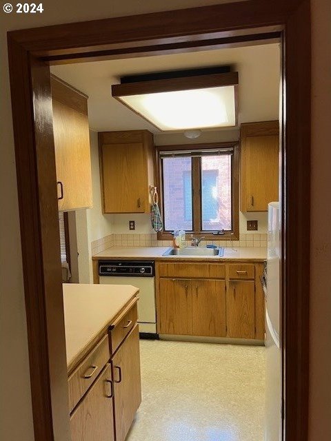 kitchen with backsplash, sink, and white appliances