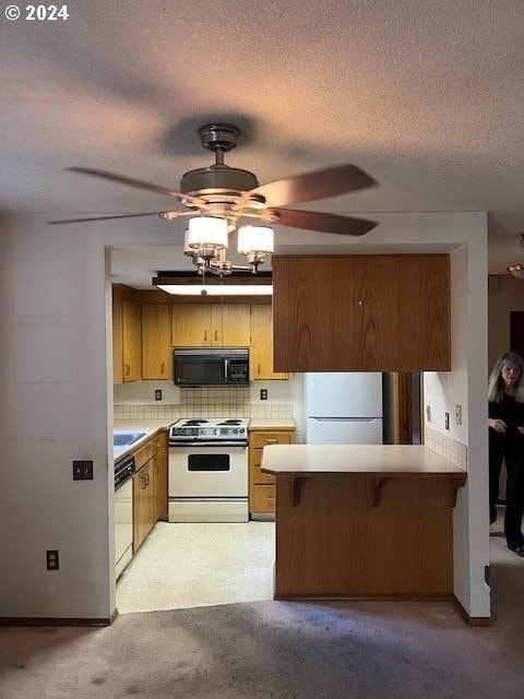 kitchen featuring light carpet, kitchen peninsula, tasteful backsplash, ceiling fan, and white appliances