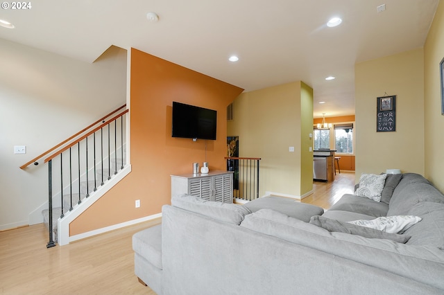 living room with light wood-type flooring and a chandelier