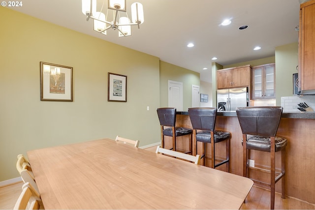 dining area featuring light wood-type flooring and a notable chandelier