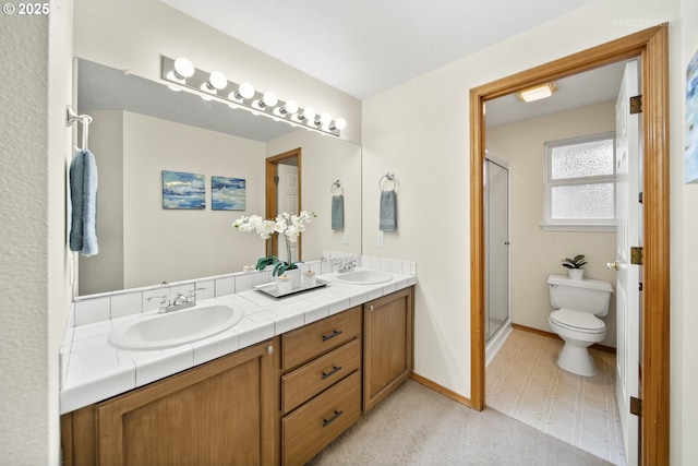 bathroom with vanity, toilet, and a shower with door