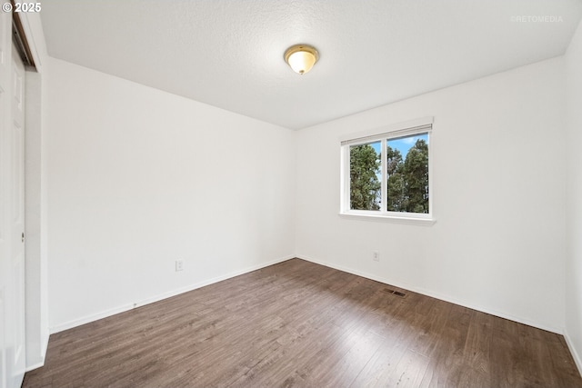 empty room with dark wood-type flooring