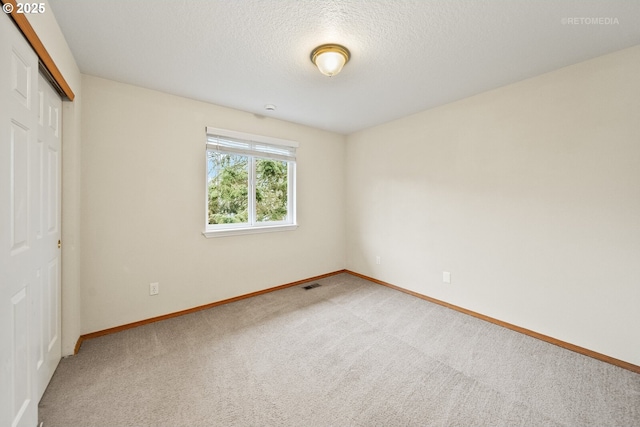 unfurnished bedroom featuring a closet, a textured ceiling, and carpet