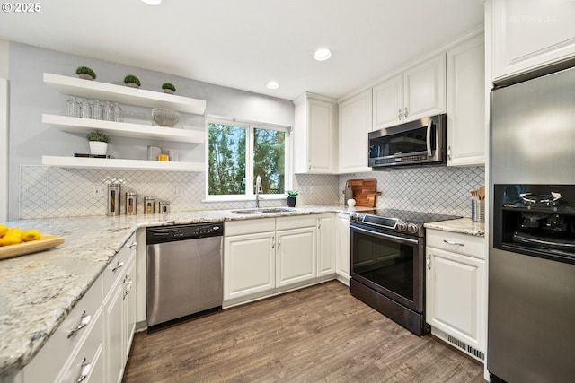 kitchen with sink, white cabinets, dark hardwood / wood-style flooring, light stone counters, and stainless steel appliances