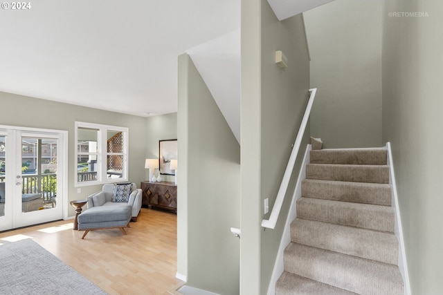 stairs featuring french doors and wood-type flooring