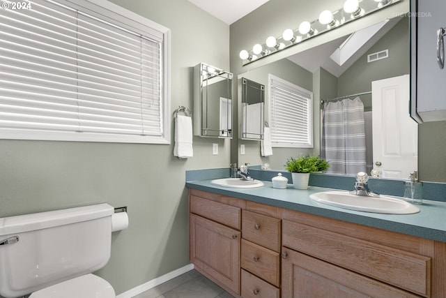 bathroom with toilet, vanity, and tile patterned floors