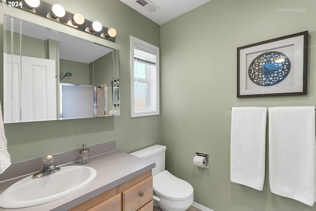 bathroom with vanity, toilet, and an enclosed shower