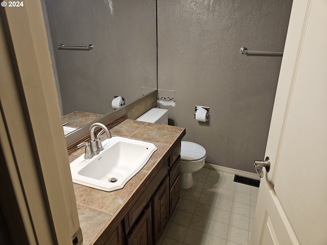 bathroom featuring tile patterned floors, vanity, and toilet