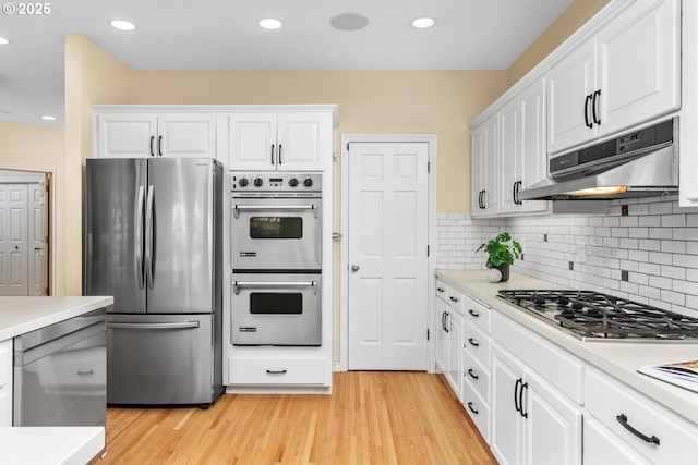 kitchen featuring decorative backsplash, white cabinetry, light hardwood / wood-style floors, and appliances with stainless steel finishes