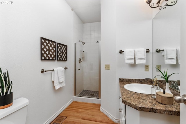 bathroom with hardwood / wood-style floors, vanity, toilet, and an enclosed shower