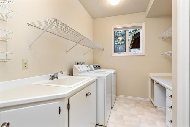 clothes washing area featuring washer and clothes dryer and sink